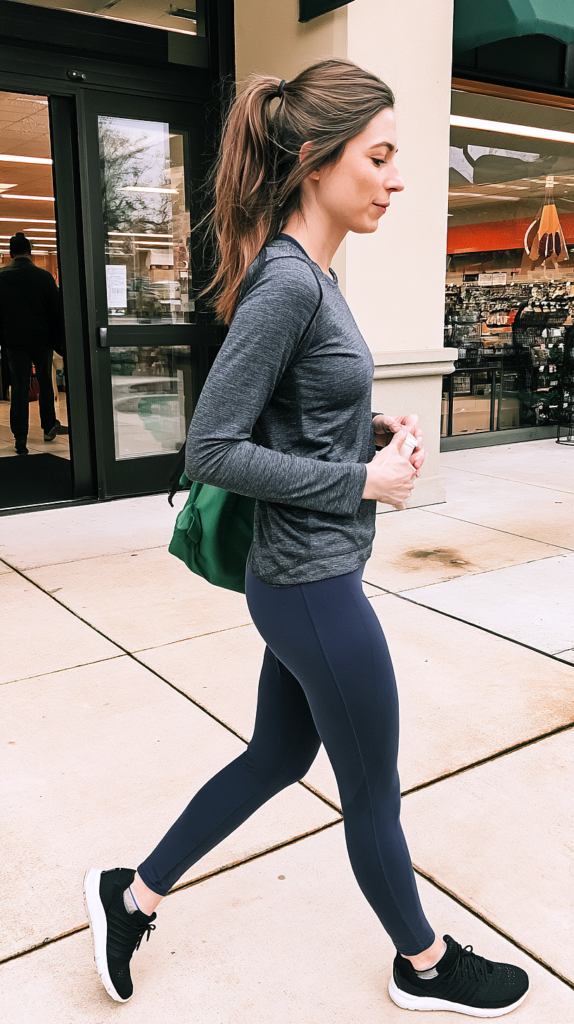 Long-sleeve top and navy leggings sporty outfit with green backpack outside a store