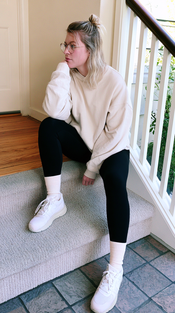 Cream sweatshirt and high socks yoga pants outfit with black leggings on home stairs